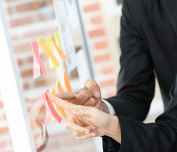 pointing-on-glass-wall-with-glued-colorful-paper-notes-note
